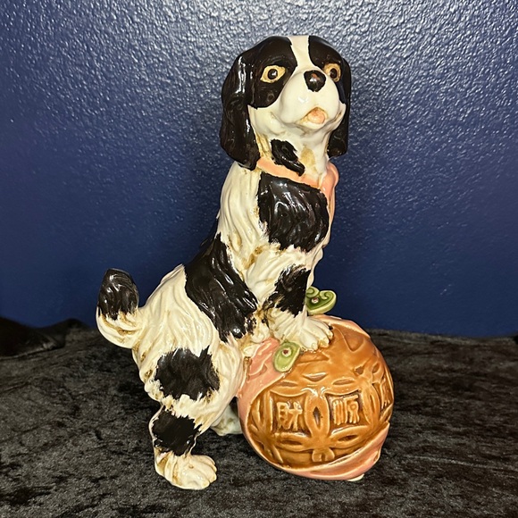 Ceramic Black and White Dog Figurine with a Brown Sphere
